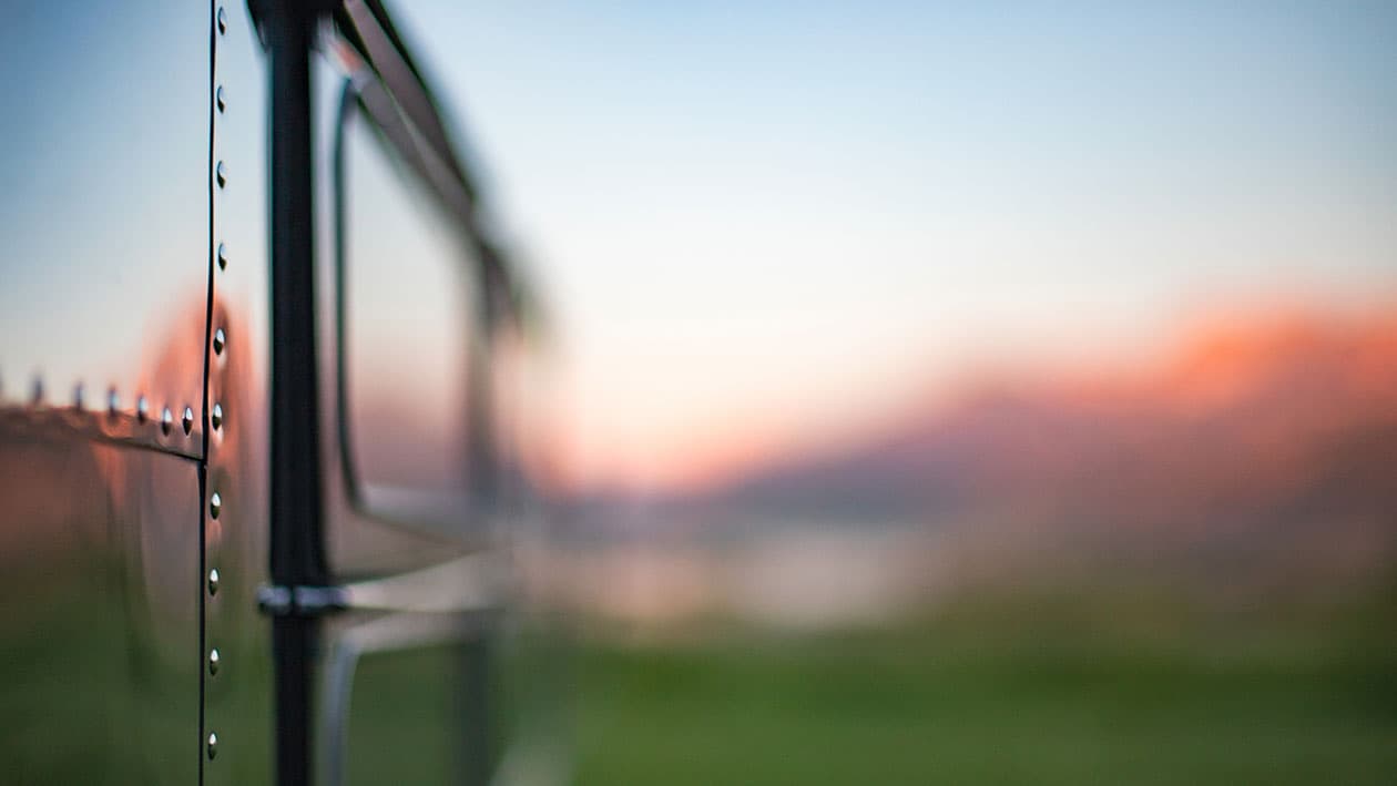 Close-up of polished aluminum siding with visible rivets and window frame detail, 1953 Silver Streak Clipper