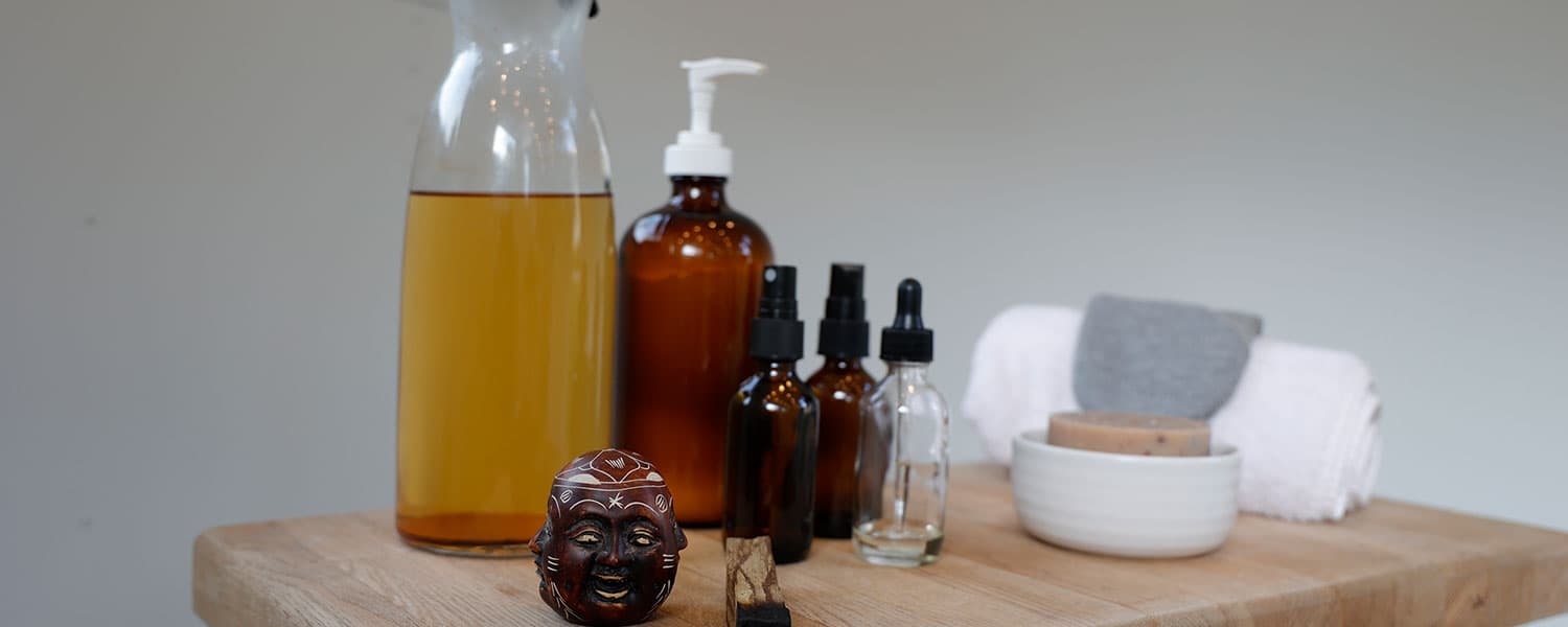 Glass and amber bottles, soap, towels, and carved figure on wooden counter inside 1959 Airstream Tradewind