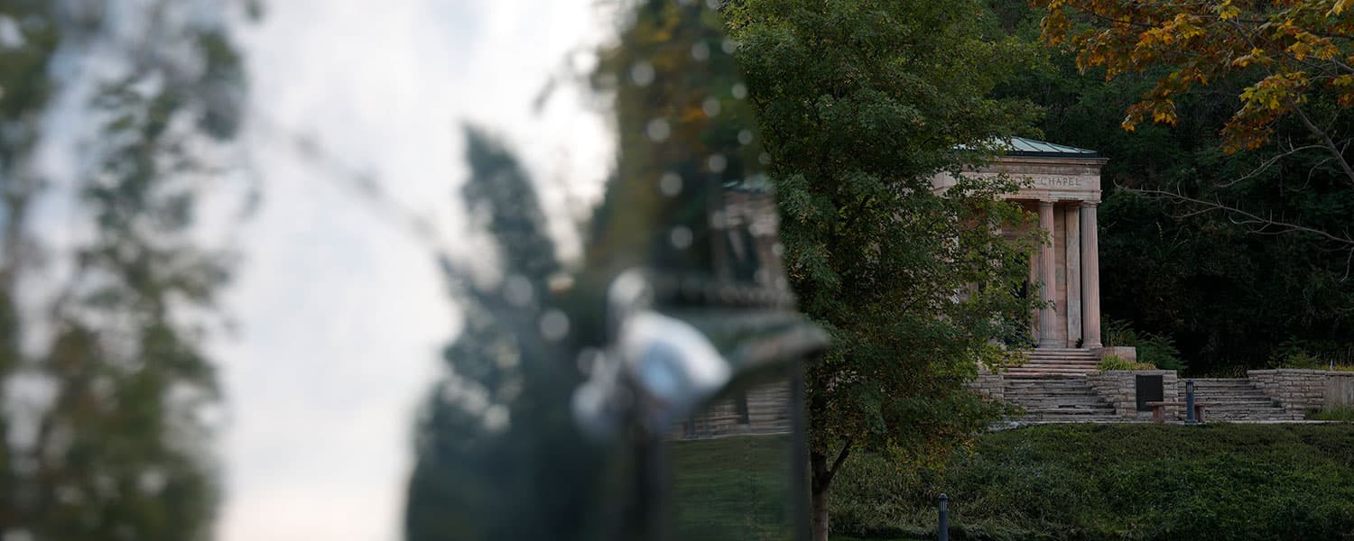 Reflection of a stone chapel captured on polished aluminum exterior skin with rivet detail, 1959 Airstream Tradewind