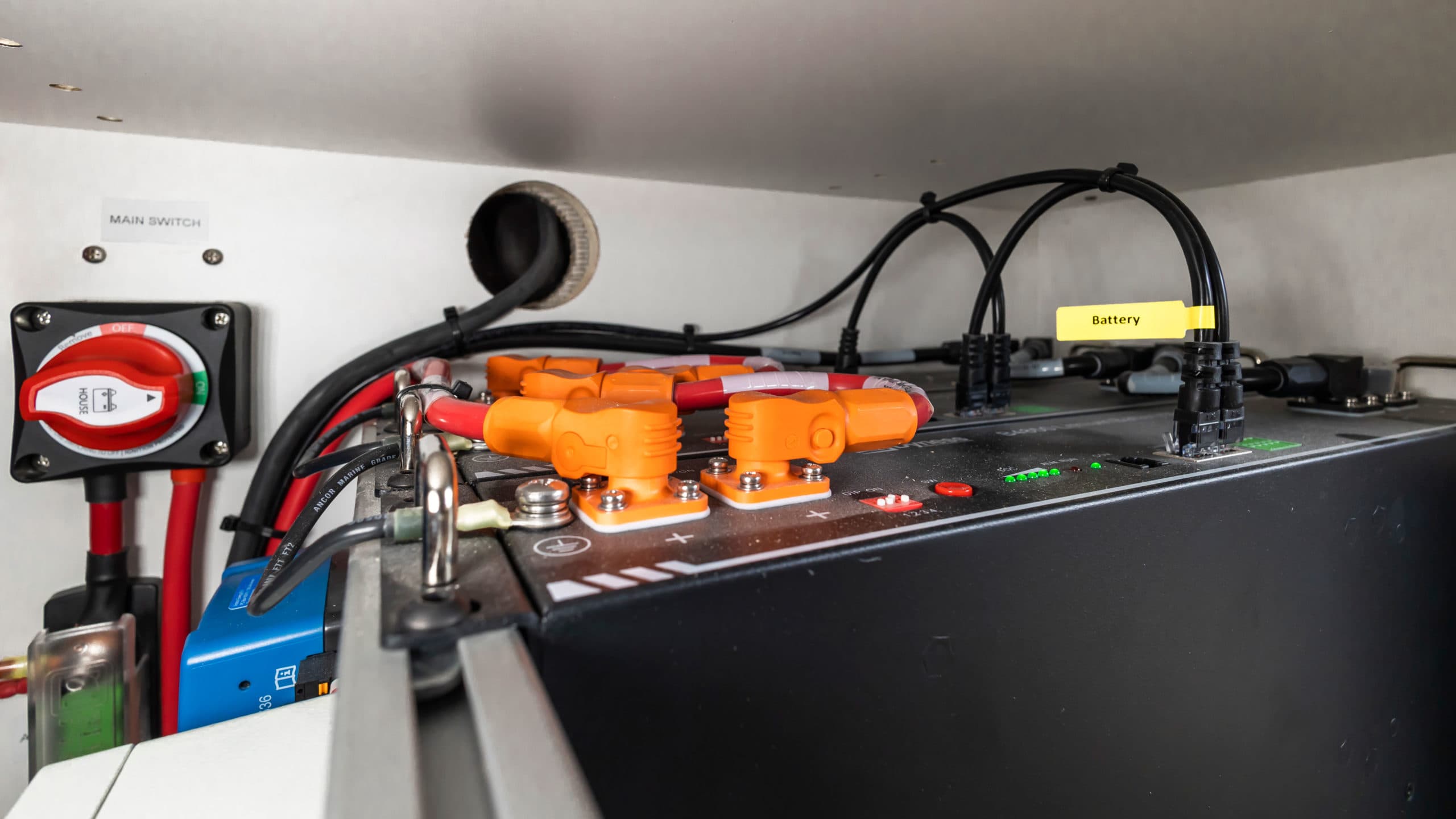 Close-up of lithium battery system with main switch, wiring, connectors, and power indicators in 4x4 Saga Sprinter Van 170