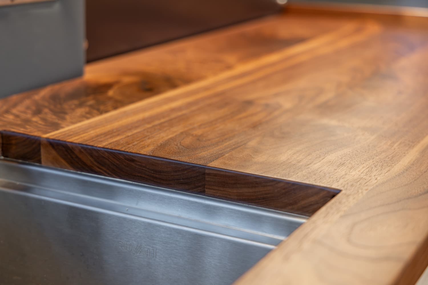 Butcher block countertop with integrated cover over stainless steel Ruvati sink in 2022 Sprinter 170 Adventure Van Saga