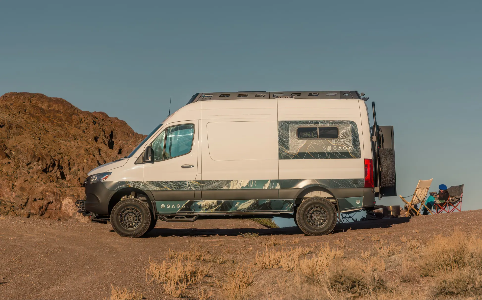 SAGA Van parked on a dirt road near rocky hills